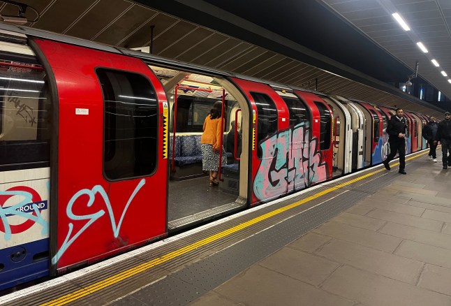 The exterior of a Central line Tube train with graffiti.