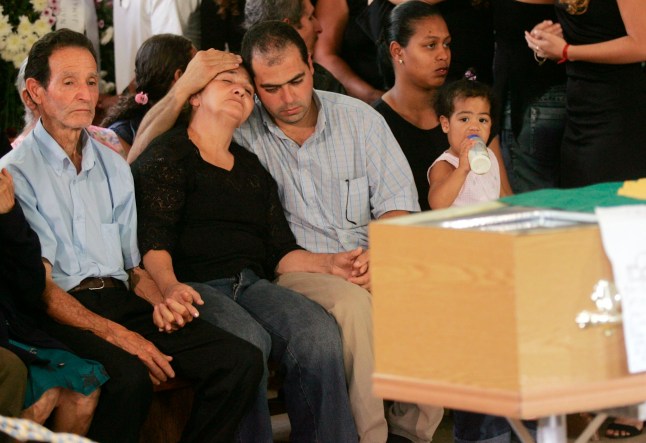 FILE - Maria Menezes, second left, is flanked by Matzinhos da Silva, left, and Giovani de Menezes, at the funeral for her son Jean-Charles de Menezes in Gonzaga, Minas Gerais State, Brazil, on July 29, 2005. (AP Photo/Silvia Izquierdo, File)