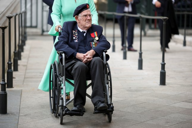 A veteran is assisted in a wheelchair as he arrives at Westminster Abbey for the Service of Thanksgiving hold as part of commemorations for the 80th anniversary.