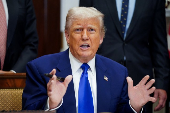 Trump makes hand gestures.