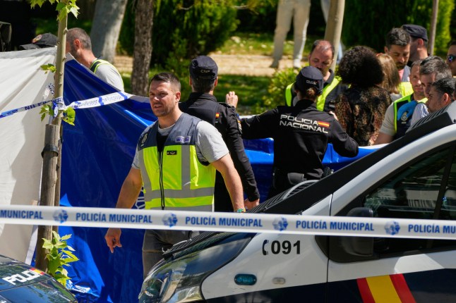 Members of the judicial police at the scene after an adviser to former Ukrainian president Viktor Yanukovych was shot, outside a school in Madrid, Spain, Wednesday, May 21, 2025. (AP Photo/Paul White)